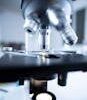 Detailed view of a laboratory microscope focusing on lens and optical components.